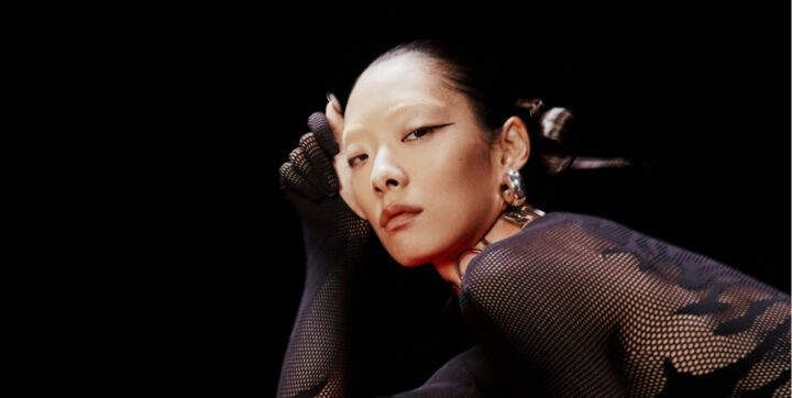 Rina Sawayama posed wearing a sheer black top.